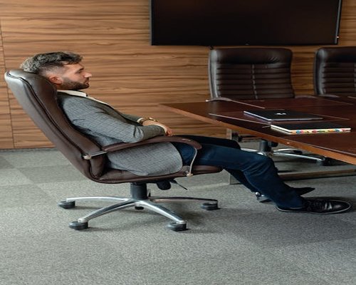 Person doing a gentle neck stretch while sitting on an ergonomic office chair